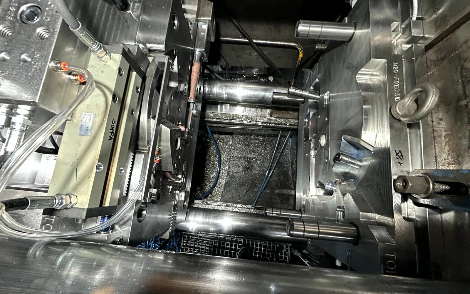 Lo stampo aperto dentro la pressa, con i tiranti e i pistoni dell'estrazione
